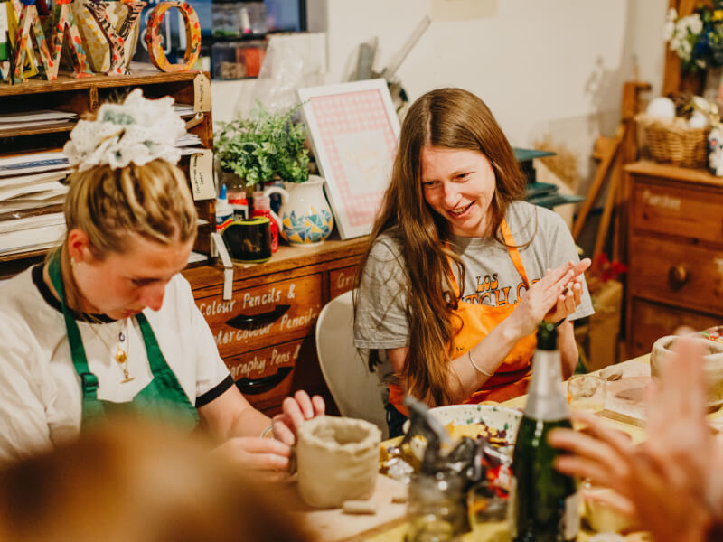 Woman smiling at a pottery class. 